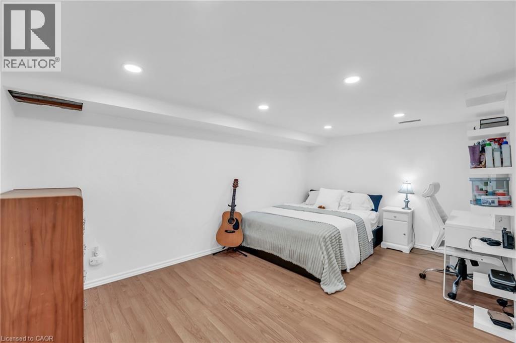 Spacious room featuring wood-finish flooring, recessed lighting, and white baseboards - 25 Park Street E, Hamilton, ON - Indoor Photo Showing Bedroom