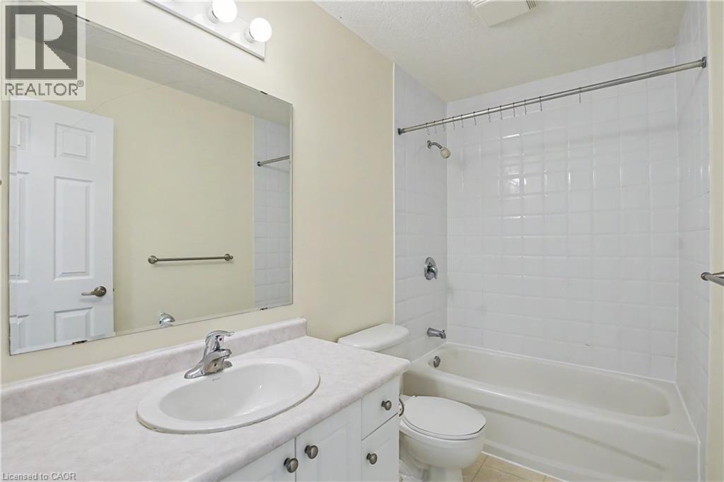 Bathroom vanity featuring a white oval sink with chrome faucet, set into a light-toned countertop - 619 Wild Ginger Avenue Unit# C15, Waterloo, ON - Indoor Photo Showing Bathroom