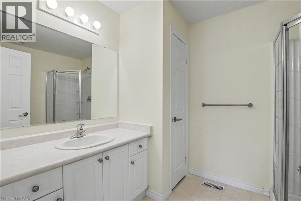 Bathroom vanity with an integrated sink, white cabinetry, and a laminate countertop - 619 Wild Ginger Avenue Unit# C15, Waterloo, ON - Indoor Photo Showing Bathroom