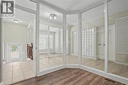 Interior space featuring wood-finish flooring, a glass block wall, and mirrored sliding doors -