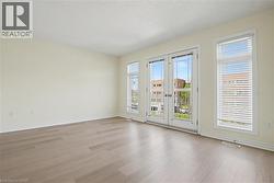 Expansive room featuring wood-finish flooring, light-colored walls, and white trim -