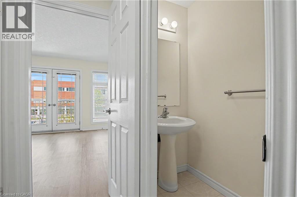 Bright room featuring double French doors, a window with horizontal blinds, and wood-finish flooring - 619 Wild Ginger Avenue Unit# C16, Waterloo, ON - Indoor Photo Showing Bathroom