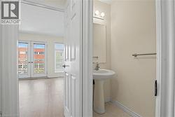 Bright room featuring double French doors, a window with horizontal blinds, and wood-finish flooring -