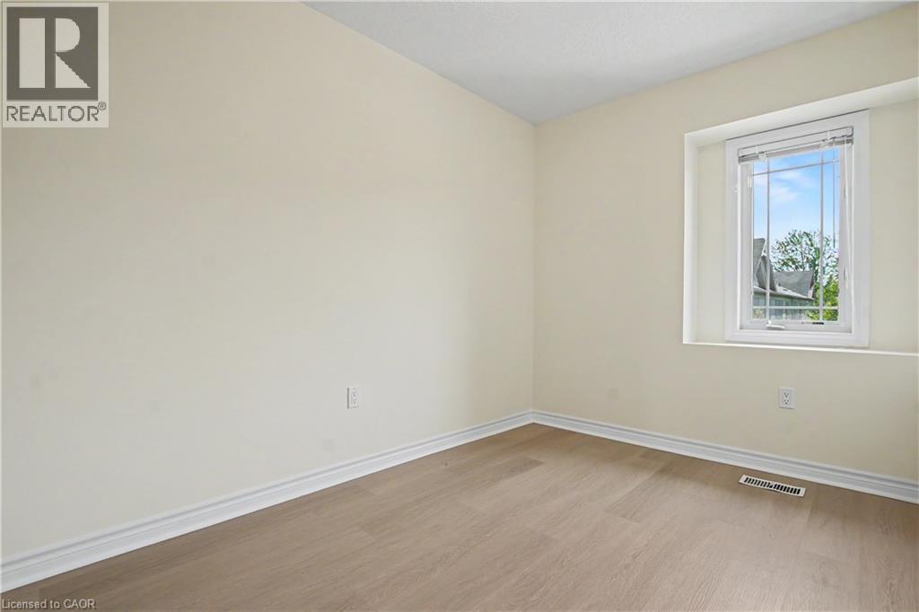 Room featuring light-colored walls and wood-finish flooring - 619 Wild Ginger Avenue Unit# C16, Waterloo, ON - Indoor Photo Showing Other Room