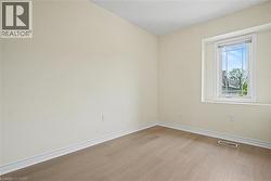 Room featuring light-colored walls and wood-finish flooring -