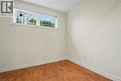 Neutral wall paint with wood-finish flooring and white baseboards -