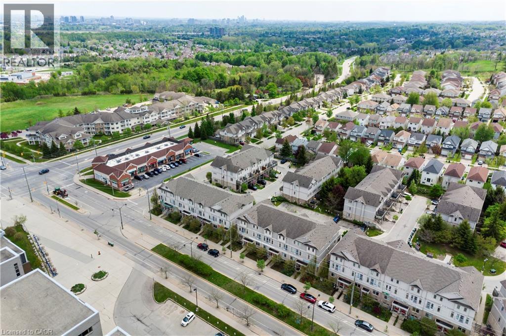 Aerial perspective showcasing a residential area featuring single-family homes, townhouses, and multi-unit buildings - 619 Wild Ginger Avenue Unit# C16, Waterloo, ON - Outdoor With View