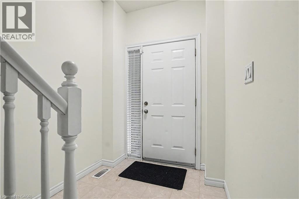 Entryway featuring a paneled door with a sidelight, a painted baluster, and neutral wall tones - 619 Wild Ginger Avenue Unit# C16, Waterloo, ON - Indoor Photo Showing Other Room