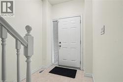 Entryway featuring a paneled door with a sidelight, a painted baluster, and neutral wall tones -