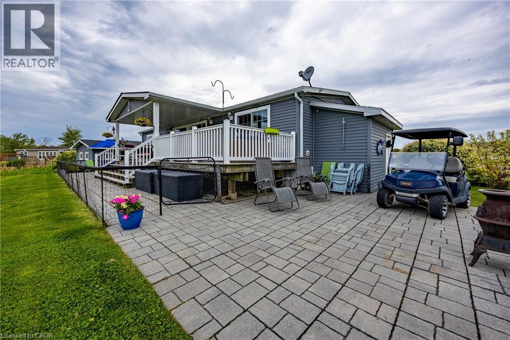 Back of 2 Hickory Hollow depicting patio, back deck, attached shed to the right and detached garage in the background - 2 Hickory Hollow, Nanticoke, ON - Outdoor With Deck Patio Veranda With Exterior
