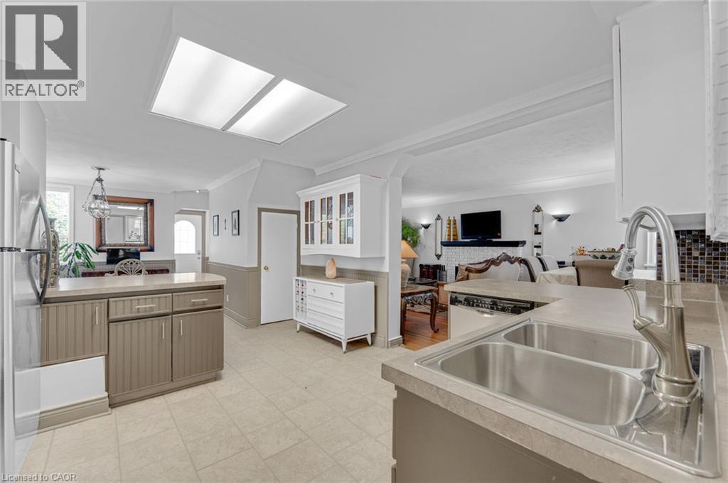 Kitchen featuring a double basin stainless steel sink with a high-arc faucet, neutral countertops, and tile flooring - 1 Galbraith Drive, Hamilton, ON - Indoor Photo Showing Kitchen With Double Sink