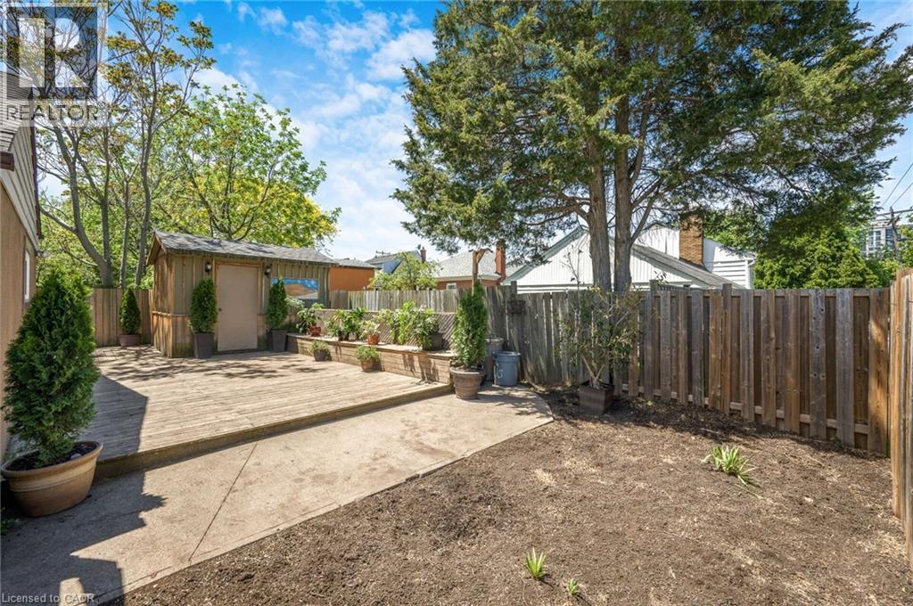 Spacious backyard featuring a wooden deck, concrete patio, and a dedicated garden shed - 1 Galbraith Drive, Hamilton, ON - Outdoor