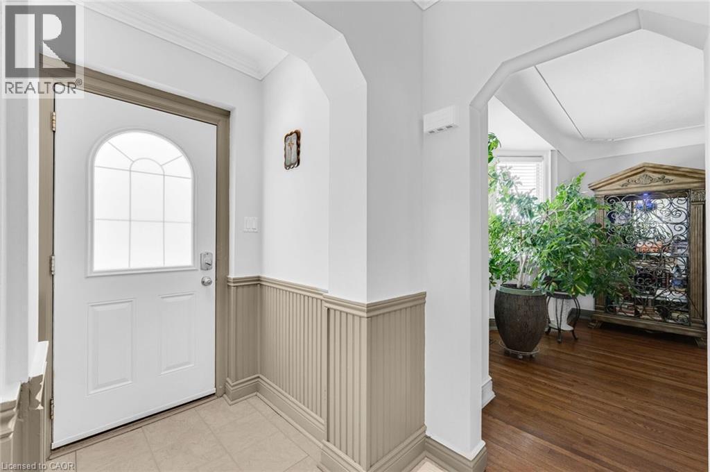Entryway featuring a white door with an arched decorative glass insert, beadboard wainscoting, and crown molding - 1 Galbraith Drive, Hamilton, ON - Indoor Photo Showing Other Room
