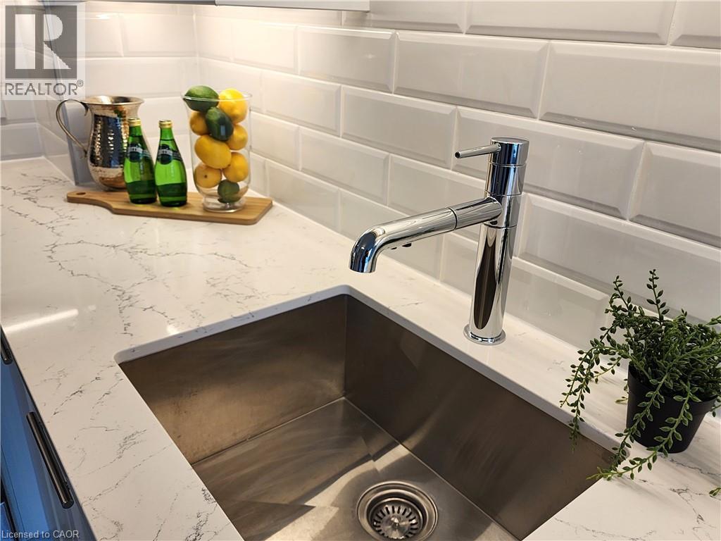 Stainless steel undermount sink, a chrome faucet, and white subway tile backsplash - 385 Winston Road Unit# 709, Grimsby, ON - Indoor