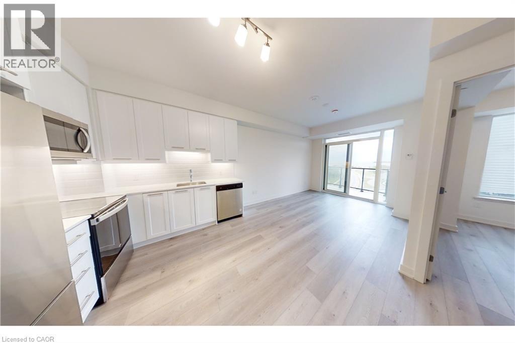 Open-concept living space with light wood-finish flooring - 385 Winston Road Unit# 709, Grimsby, ON - Indoor Photo Showing Kitchen