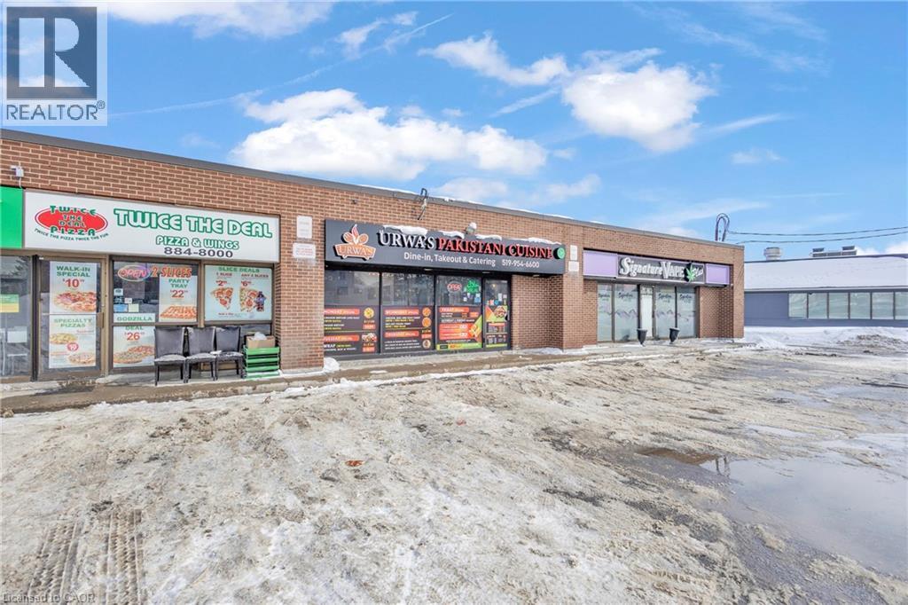 Commercial storefronts featuring brick exteriors, multiple display windows, and prominent signage - 402 King Street N, Waterloo, ON