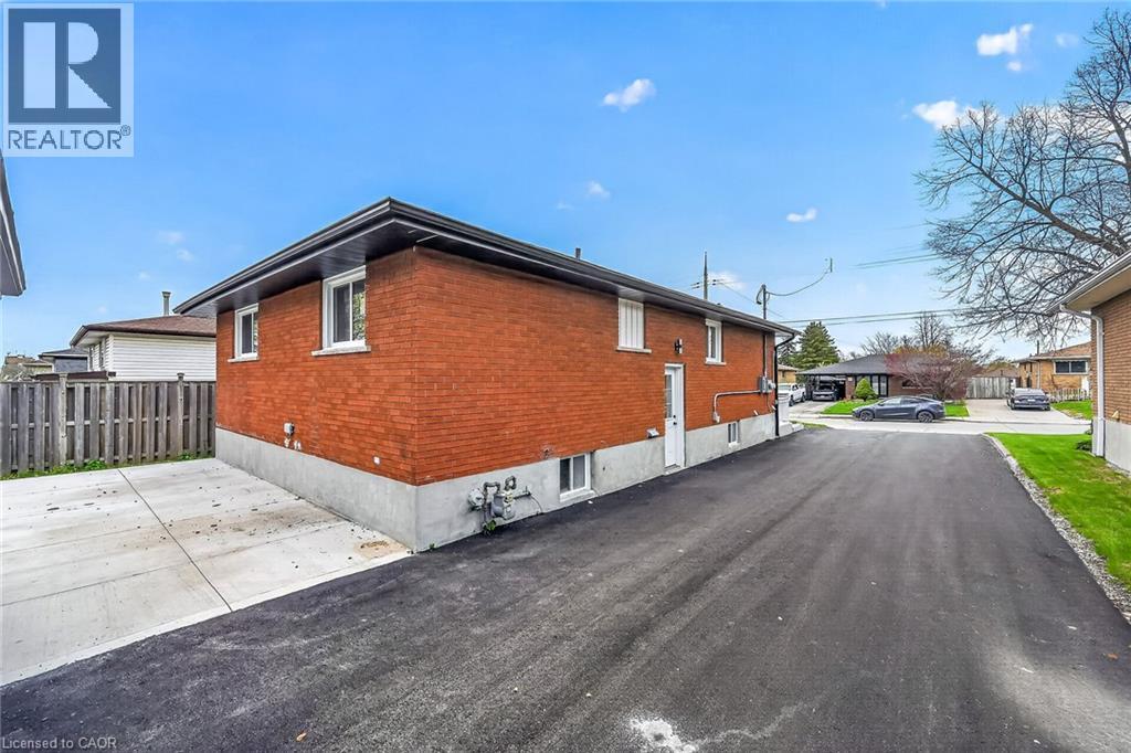 Red brick exterior with white trim windows and a black shingle roof - 74 Victor Boulevard, Hamilton, ON - Outdoor With Exterior