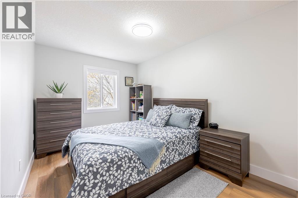 Bedroom featuring wood-finish flooring, white walls, and a window with white trim - 185 Highland Crescent Unit# 2, Kitchener, ON - Indoor Photo Showing Bedroom
