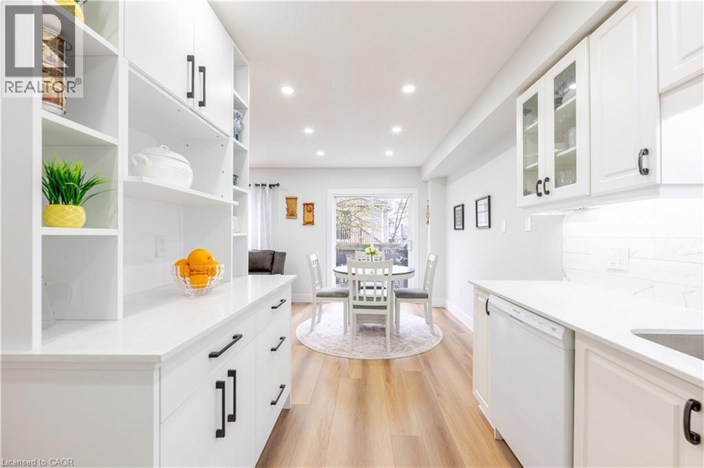 Modern kitchen featuring extensive white cabinetry with matte black hardware, white countertops, and a white subway tile backsplash - 185 Highland Crescent Unit# 2, Kitchener, ON - Indoor Photo Showing Kitchen
