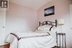 Room with wood-finish flooring and a vaulted ceiling -