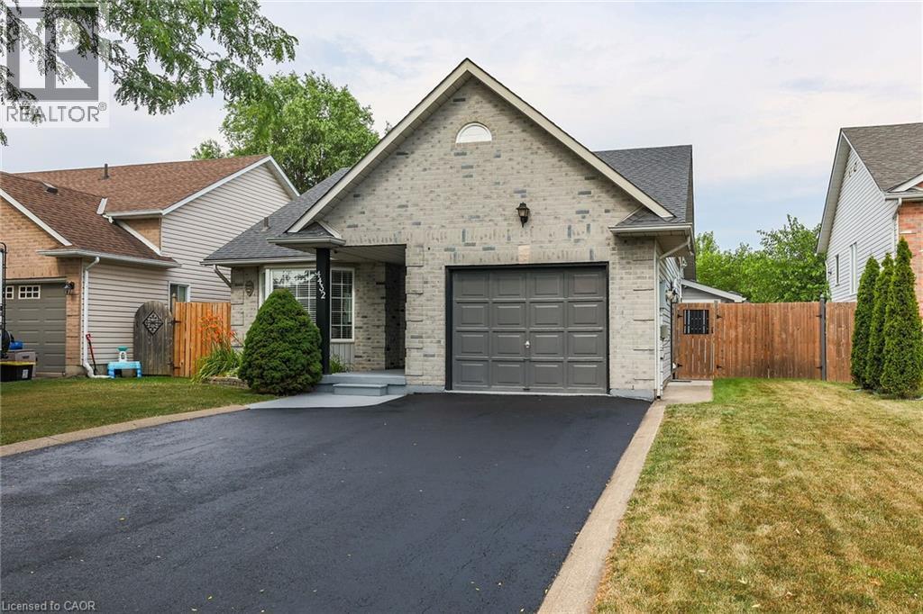 View of front of property with a garage, driveway, a gate, and brick siding - 4432 Dennis Avenue, Beamsville, ON - Outdoor