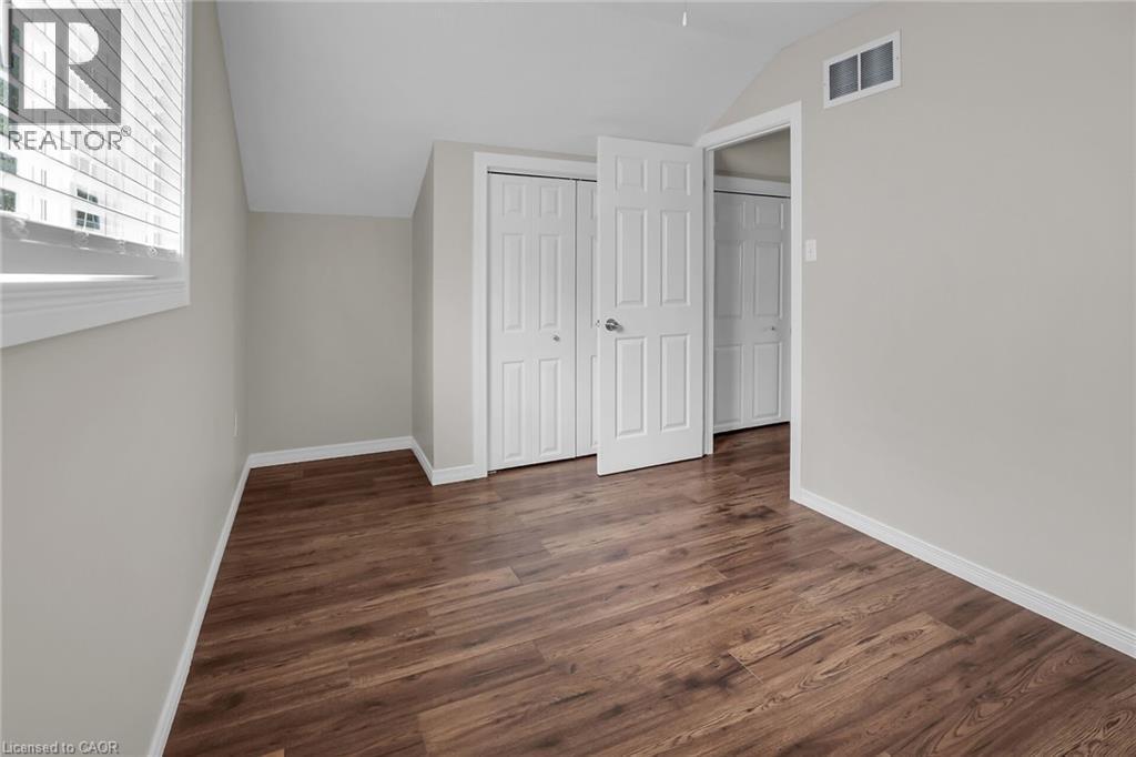 Second floor bedroom with vaulted ceiling, dark wood-style floors, and a closet - 4432 Dennis Avenue, Beamsville, ON - Indoor Photo Showing Other Room