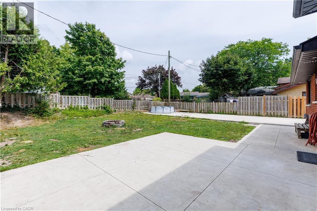 Expansive concrete patio with a grass lawn area - 18 Silverdale Crescent, London, ON - Outdoor