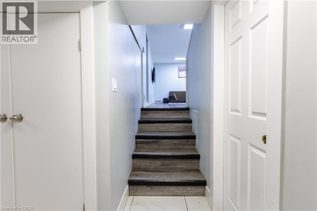 Staircase with wood-finish treads and risers, featuring a white painted handrail - 18 Silverdale Crescent, London, ON - Indoor Photo Showing Other Room
