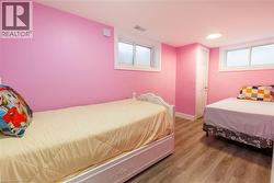 Room featuring pink walls and wood-finish flooring -