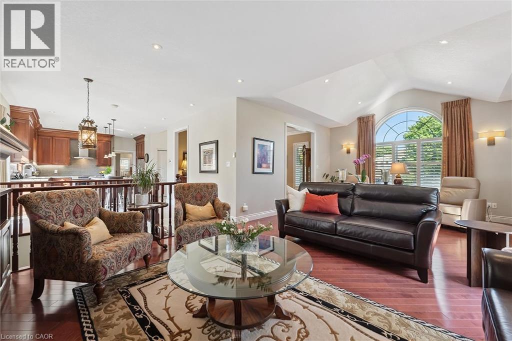 Living area featuring rich wood-finish flooring, a vaulted ceiling, and an arched window with louvered shutters - 20 Bonniewood Drive, Drayton, ON - Indoor Photo Showing Living Room