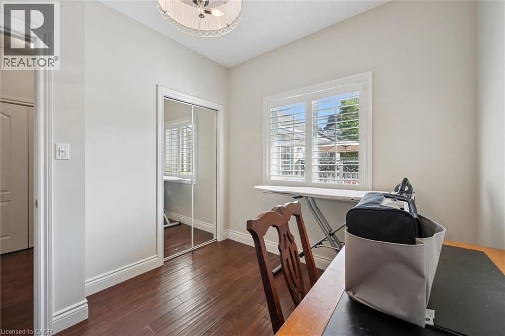 Room featuring wood-finish flooring, a window with louvered shutters, mirrored closet doors, and crown molding - 20 Bonniewood Drive, Drayton, ON - Indoor Photo Showing Office
