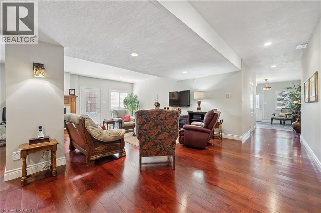 Spacious living area featuring rich wood-finish flooring, recessed lighting, and light-toned wall finishes - 20 Bonniewood Drive, Drayton, ON - Indoor Photo Showing Living Room