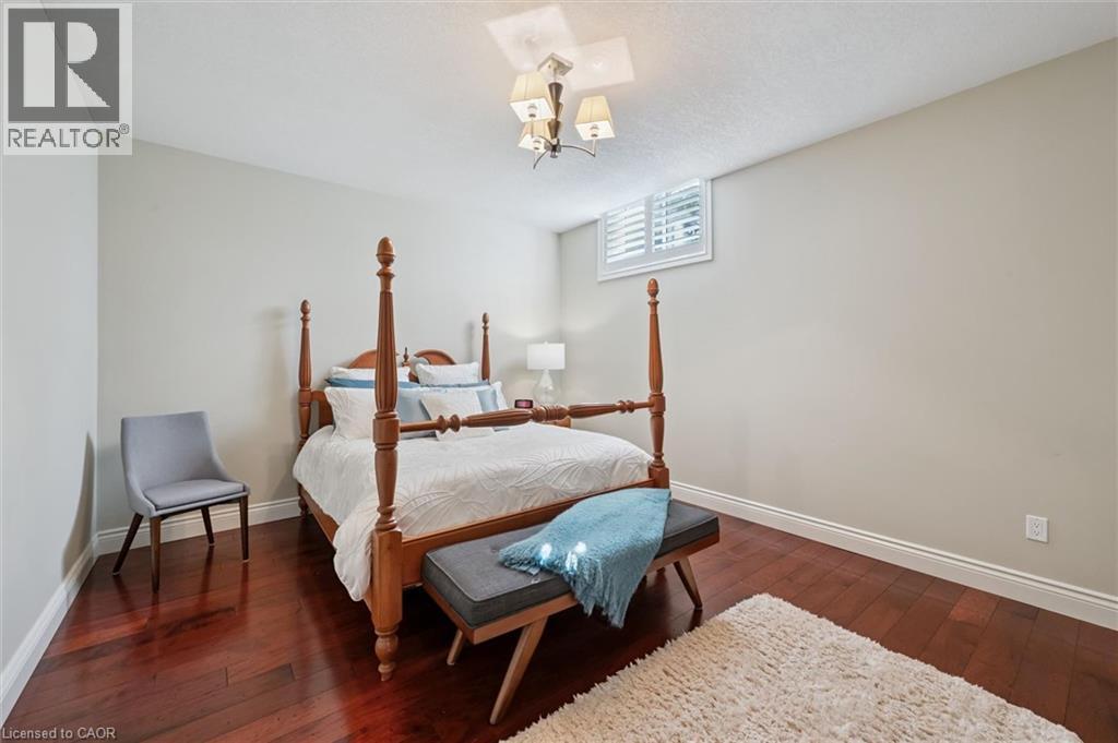 Rich wood-finish flooring complements the neutral wall tones - 20 Bonniewood Drive, Drayton, ON - Indoor Photo Showing Bedroom