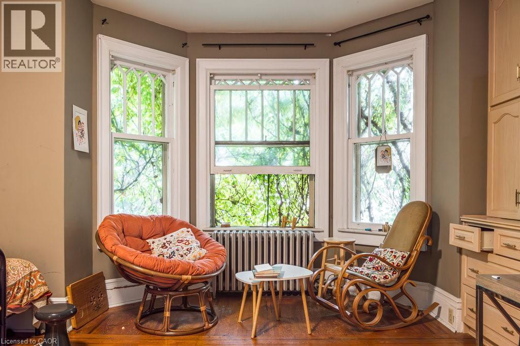 Bay window with multiple sash windows, white trim, and a radiator below - 95-97 S Fairholt Road S, Hamilton, ON - Indoor