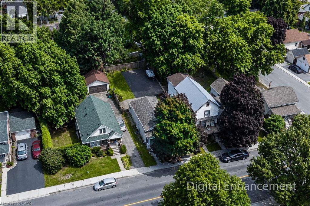 Aerial perspective showcasing a residential property with a green-shingled roof, a front porch, and a dedicated driveway - 319 King Street W, Dundas, ON - Outdoor
