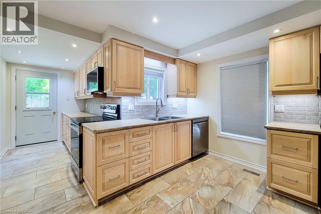 Kitchen featuring light wood cabinetry, stone-look countertops, and a subway tile backsplash - 319 King Street W, Dundas, ON - Indoor Photo Showing Kitchen