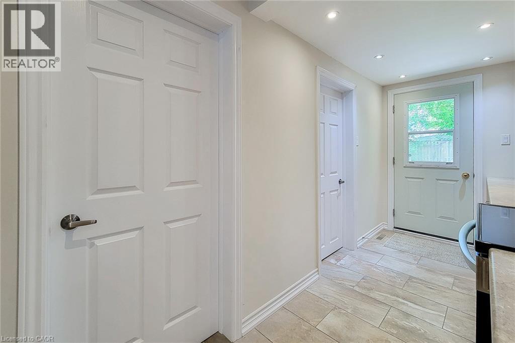 Interior hallway featuring light-toned walls, recessed ceiling lighting, and a neutral-toned tile floor - 319 King Street W, Dundas, ON - Indoor Photo Showing Other Room