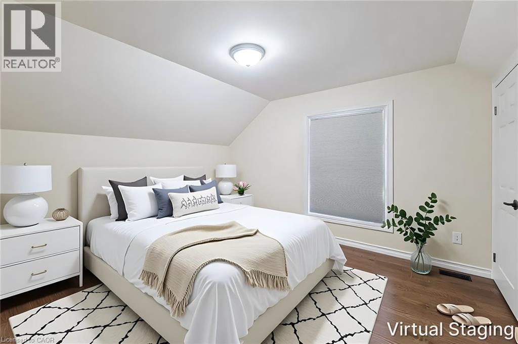 Bedroom featuring rich wood-finish flooring, a contemporary window with cellular shades, and an angled ceiling line - 319 King Street W, Dundas, ON - Indoor Photo Showing Bedroom