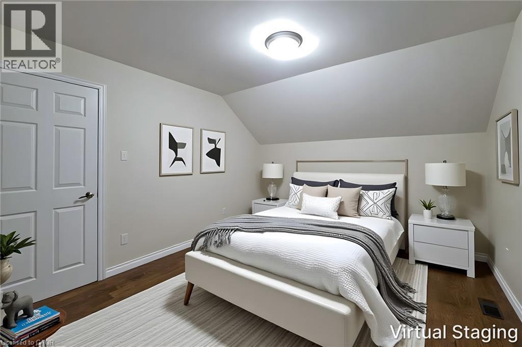 Bedroom featuring angled ceiling, recessed lighting, wood-finish flooring, and a six-panel door - 319 King Street W, Dundas, ON - Indoor Photo Showing Bedroom