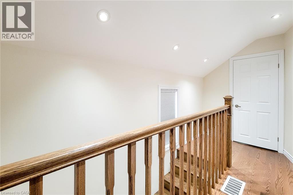 Upper landing featuring wood-finish flooring, a wood baluster railing, and recessed ceiling lighting - 319 King Street W, Dundas, ON - Indoor Photo Showing Other Room