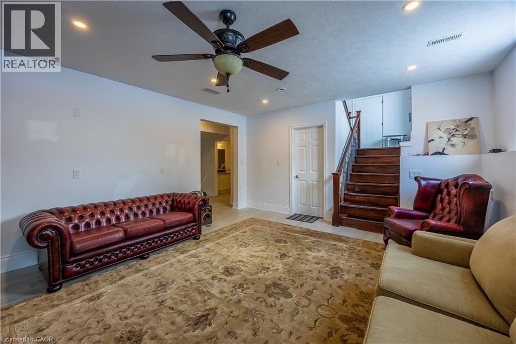 Spacious room featuring a wood-finish staircase, a ceiling fan with integrated lighting, and recessed ceiling lights - 514 Fishers Glen Road, Vittoria, ON - Indoor Photo Showing Living Room