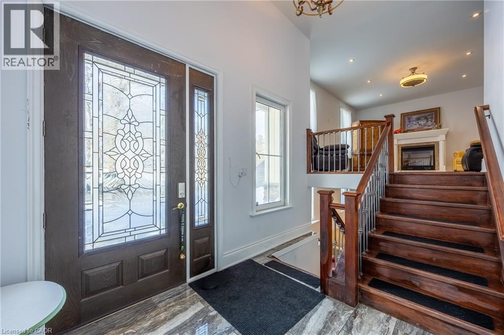 Entryway featuring a dark wood-finish door with decorative glass inserts, a matching sidelight, and marble-look flooring - 514 Fishers Glen Road, Vittoria, ON - Indoor Photo Showing Other Room