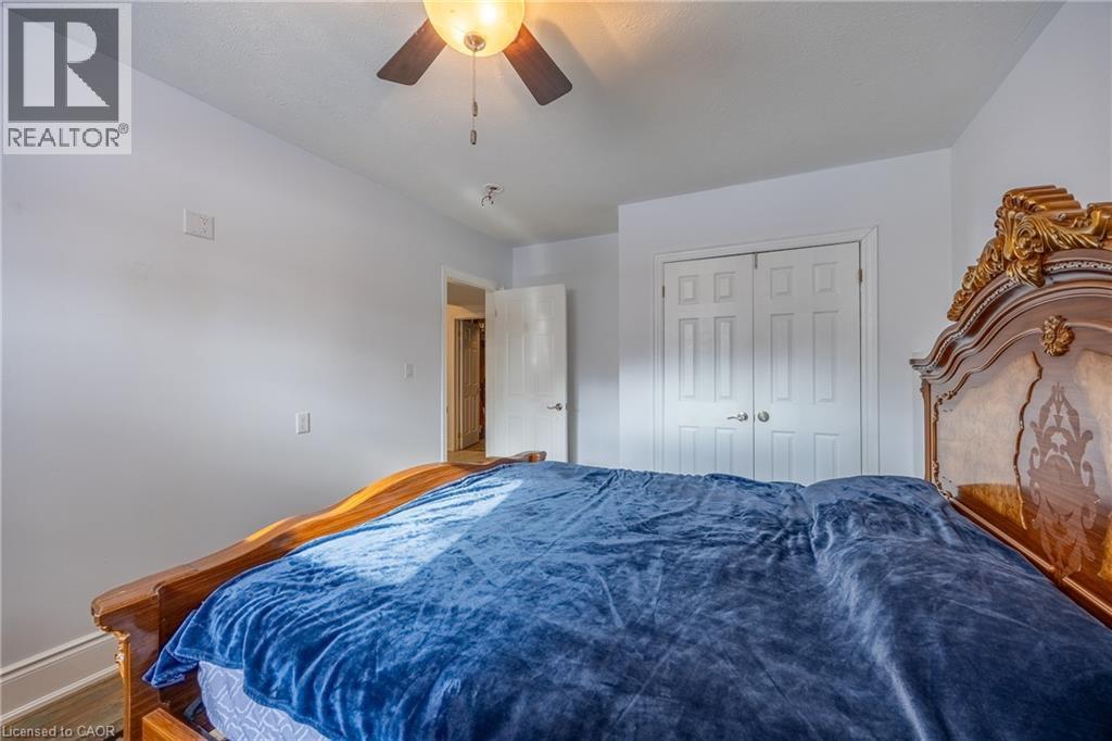 Bedroom featuring a ceiling fan with integrated lighting, white walls, and a paneled bifold closet door - 514 Fishers Glen Road, Vittoria, ON - Indoor Photo Showing Bedroom