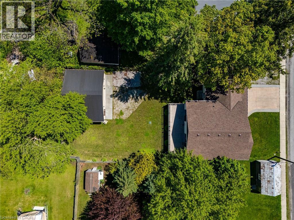 Expansive property featuring a main residence with a brown shingle roof, a detached structure with a black metal roof, and a separate storage shed - 514 Fishers Glen Road, Vittoria, ON - Outdoor