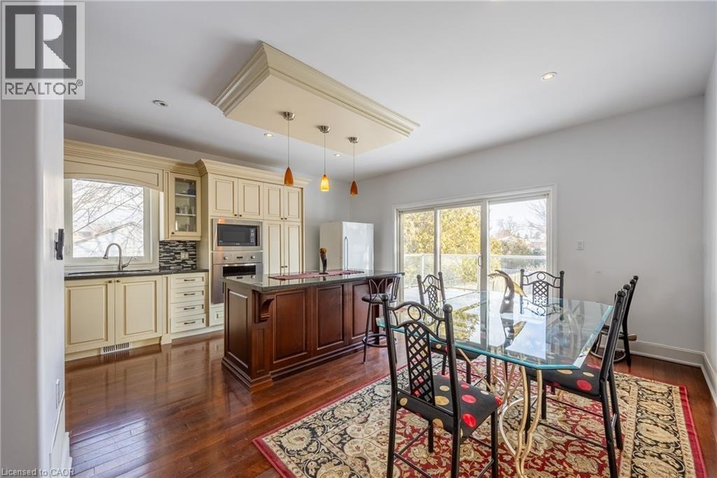Kitchen and dining area featuring warm wood-finish flooring - 514 Fishers Glen Road, Vittoria, ON - Indoor Photo Showing Dining Room