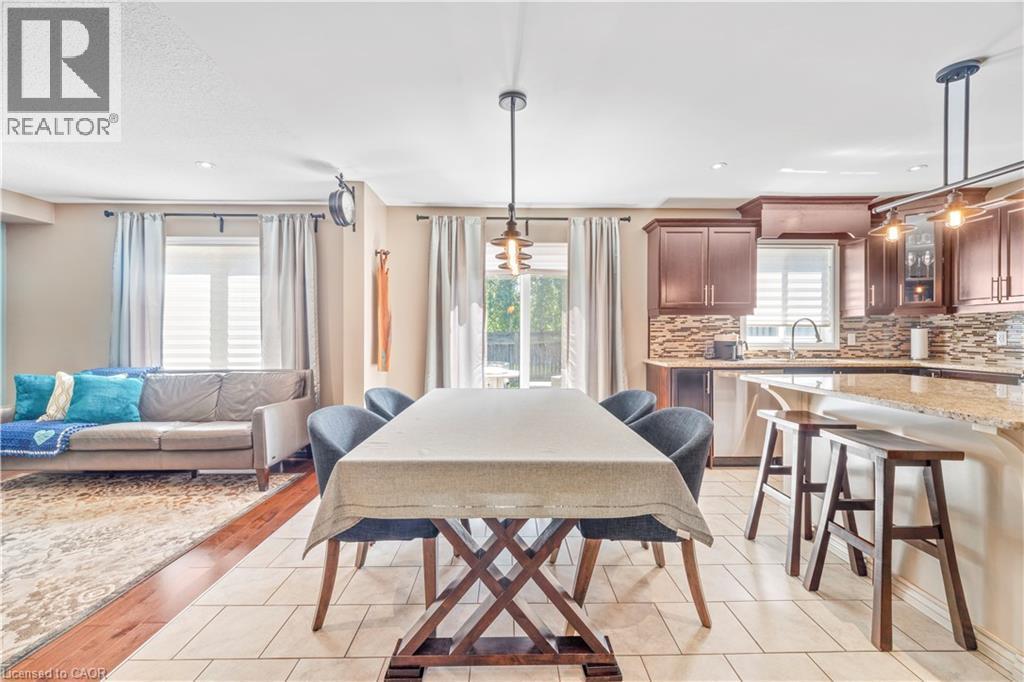 Open-concept dining and kitchen area with light-toned floor tiles - 21 Davinci Boulevard, Hamilton, ON - Indoor Photo Showing Dining Room