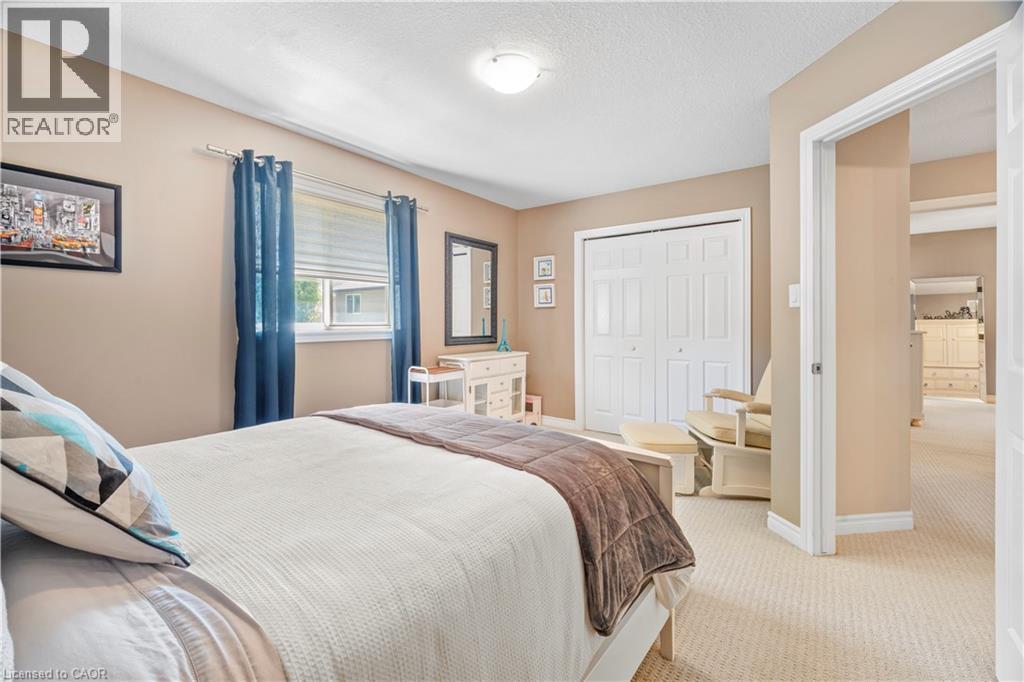 Bedroom featuring neutral wall paint, textured carpet, and white bi-fold closet doors - 21 Davinci Boulevard, Hamilton, ON - Indoor Photo Showing Bedroom