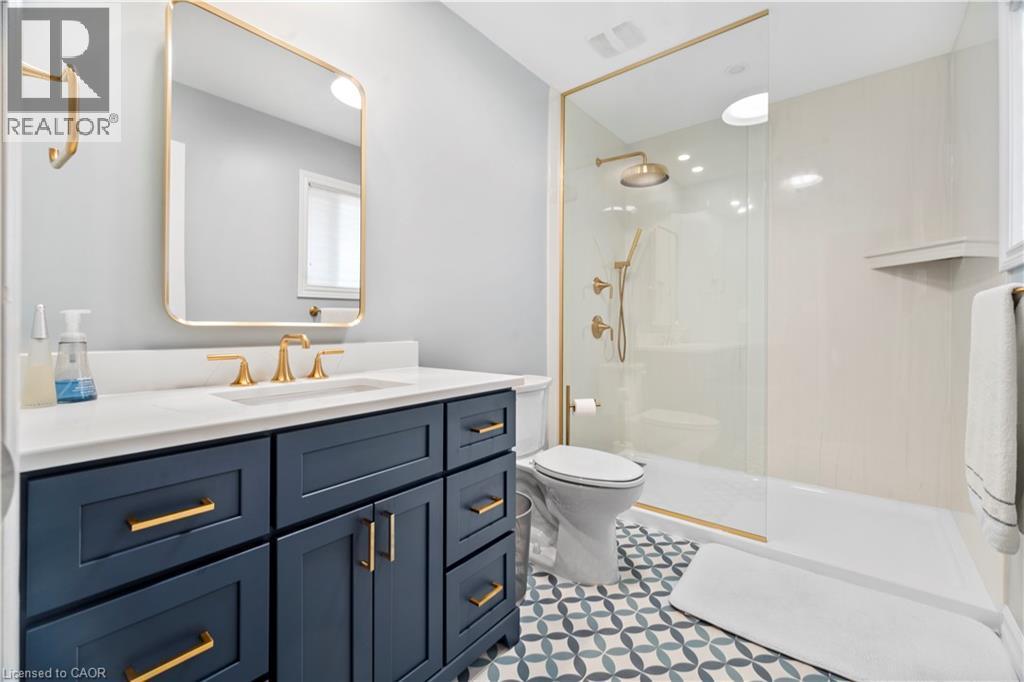 Built-in vanity with a white countertop and gold-tone fixtures - 21 Davinci Boulevard, Hamilton, ON - Indoor Photo Showing Bathroom