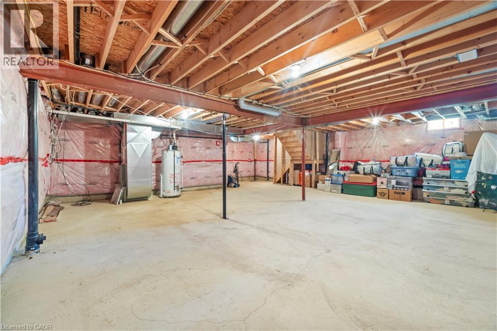 Expansive unfinished basement featuring a concrete floor, exposed wood ceiling joists, and a visible water heater - 21 Davinci Boulevard, Hamilton, ON - Indoor Photo Showing Basement