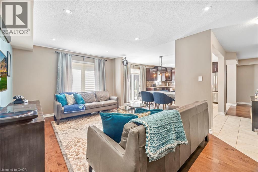 Living area featuring recessed lighting, wood-finish flooring, and neutral wall tones - 21 Davinci Boulevard, Hamilton, ON - Indoor Photo Showing Living Room